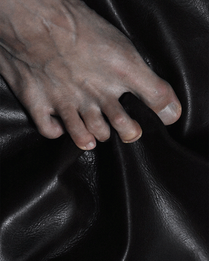 CUOIUM product close-up showing a hand on leather surface.