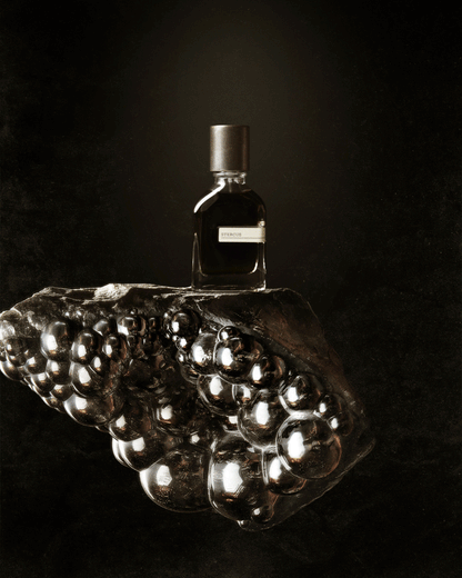 STERCUS perfume on elegant glossy stone, symbolizes life's cycle.